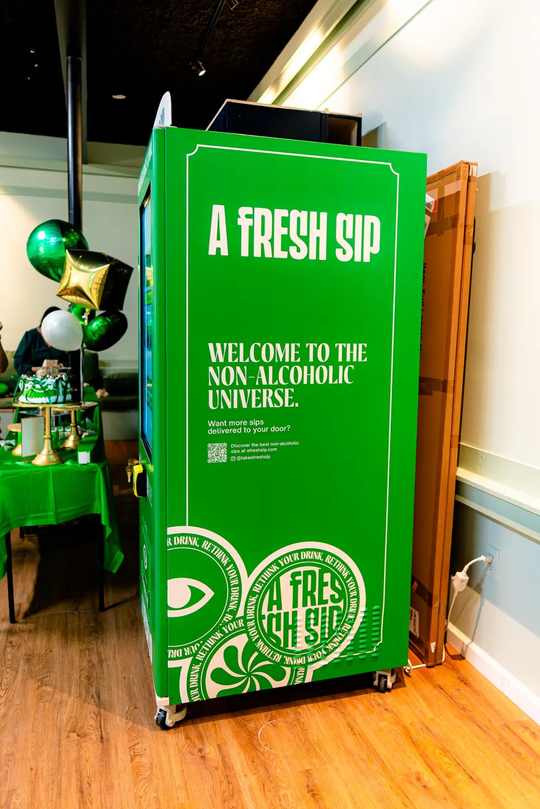Custom green A Fresh Sip wrap on the side of the Sip Shop smart vending machine